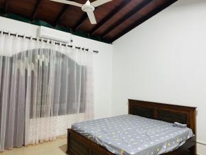 a bedroom with a bed and a ceiling fan at Kashmir villa in Galle