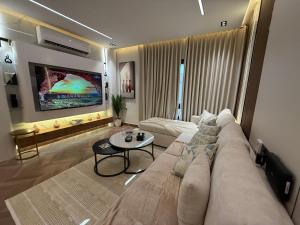 a living room with a large couch and a table at الملقا جاكوزي لوفت Al Malqa Jacuzzi Loft in Riyadh