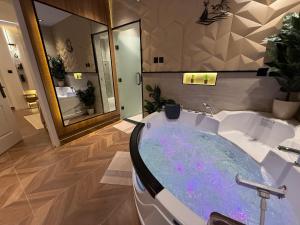 a bathroom with a bath tub with a sink at الملقا جاكوزي لوفت Al Malqa Jacuzzi Loft in Riyadh +33 photos
