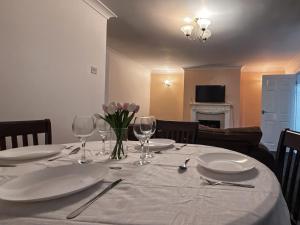 una mesa de comedor con platos y copas de vino en Vicky and sons Ltd, en Monkwearmouth