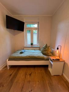 ein kleines Schlafzimmer mit einem Bett und einem Fenster in der Unterkunft Wohlfühlquartier Bitterfeld - Monteurswohnung in Bitterfeld