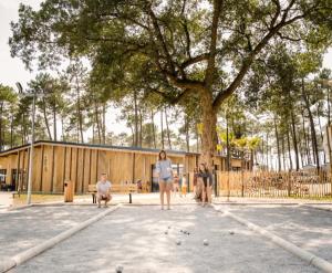 a group of people standing in front of a tree at Mobil-home neuf sous les pins, à proximité des infrastructures in Saint-Julien-en-Born