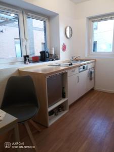 a kitchen with a sink and a desk with a tv at Noorstübchen in Eckernförde