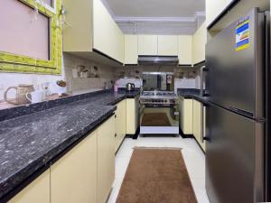 Sheikh ZayedにあるCK_212 . Spacious 2BR Apt. 2 Bathsの黄色のキャビネットとステンレス製の冷蔵庫を備えた広いキッチン