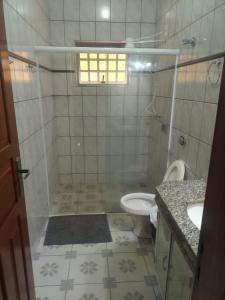 une salle de bain avec une douche avec des toilettes et un lavabo dans l'établissement Casa temporada São Roque - MG, à São Roque de Minas