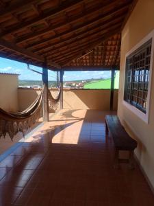 une véranda avec un banc sur le côté du bâtiment dans l'établissement Casa temporada São Roque - MG, à São Roque de Minas