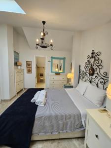 een slaapkamer met een groot bed met een kroonluchter bij Saturno 1 Sea Views Los Alamos in Torremolinos +26 foto's