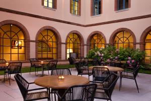 an outdoor patio with tables and chairs and flowers at Abbaye des Capucins Spa & Resort in Montauban