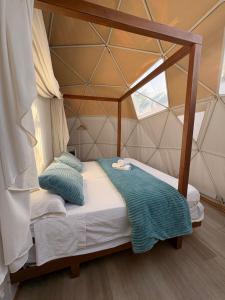 Un dormitorio con una cama con dosel en una tienda de campaña. en ADAMA Glamping, en Chiclana de la Frontera