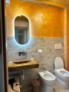 a bathroom with a sink and a toilet and a mirror at Le Stanze di Bimba in Terni