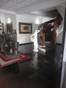 a living room with a spiral staircase and a statue at Orange Residence and Suites in Enugu