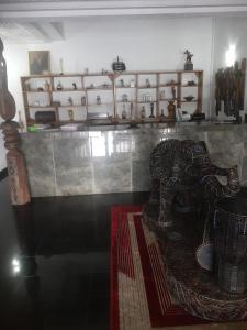 a room with a chair and shelves of vases at Orange Residence and Suites in Enugu