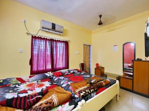 a bedroom with a bed and a tv on the wall at Hotel Cosy Inn in Digha