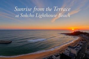 束草市Sokcho Summitbay 1209 "Ocean View"的从萨尔萨灯塔海滩的露台上欣赏日出