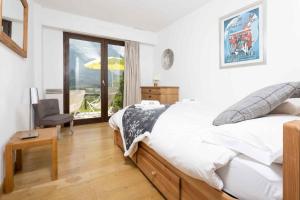 1 dormitorio con 1 cama, 1 silla y 1 ventana en Le Cretet 2 apartment - Chamonix All Year, en Chamonix-Mont-Blanc