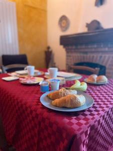 a table with a red checkered table cloth with pastries on it at Villa La Quercia Country House in Sommariva del Bosco