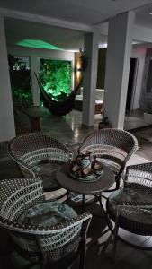 a room with chairs and a table and a hammock at Lugar Aconchecante 2 Ap 102 in Palhoça