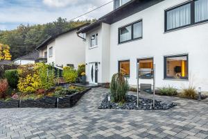 a white house with a garden in front of it at Ferienwohnung Kraus 