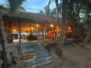 ein Haus am Strand mit Palmen in der Unterkunft IN Lanka Hotel and Restaurant in Tangalle