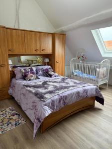 Un dormitorio con una cama grande y una cuna. en Garden House, en Saint-Benin-dʼAzy