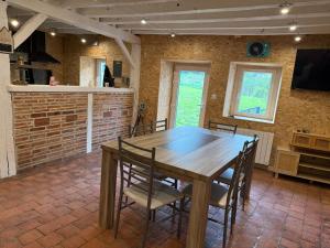 Un comedor con mesa y sillas de madera. en Garden House, en Saint-Benin-dʼAzy