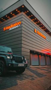 a jeep parked in front of a building at Radission in Padinjarathara