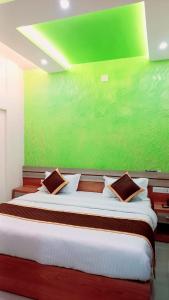 a bedroom with a large bed with a green wall at Radission in Padinjarathara