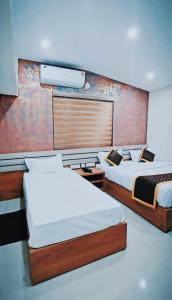 a bedroom with two beds and a wall at Radission in Padinjarathara