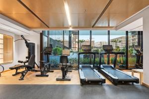 Un gimnasio con cintas de correr y equipos de ejercicio en un edificio. en Riviera Azure Gateway Superior- 10min to Burj Khalifa, Dubai Mall and Airport and 20min to Marina, en Dubái