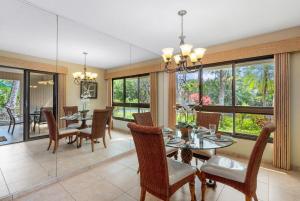 a dining room with a table and chairs and windows at Kaanapali Alii 411 · ALII 411 Ground Floor 2BD at OceanFront Res in Lahaina