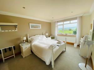 a bedroom with a large white bed and a window at Mooredge Guest House in Whitby