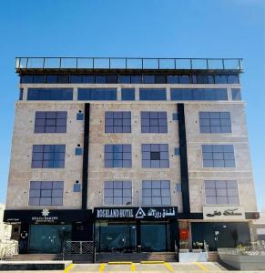 a building with a sign on the front of it at Rose Land Hotel in Umm Lujj