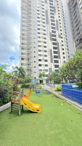 a playground with a slide on the grass in front of a building at LM50L2 horizon101 cebu in Cebu City