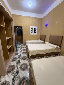 a hotel room with two beds and a carpet at كامب سيوة اواسيس Siwa Oasis Camp in Siwa