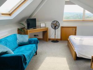 a room with a couch and a desk and a bed at Mooredge Guest House in Whitby