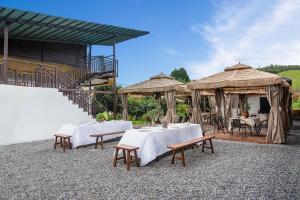 a restaurant with tables and chairs and umbrellas at Xinwo Homestay in Pan-na-meng-hun