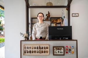 a woman standing behind a counter in a shop at Xinwo Homestay in Pan-na-meng-hun
