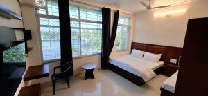 Antariksh - IN UDAIPUR في أودايبور: غرفة نوم بسرير ومكتب ونوافذ