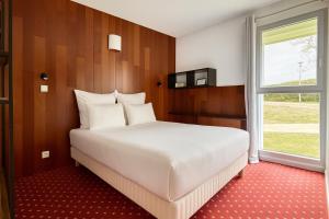 ein Schlafzimmer mit einem weißen Bett und einem Fenster in der Unterkunft Hôtel Restaurant Le Brennus in Langon