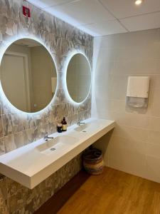 ein Badezimmer mit zwei Waschbecken und einem großen Spiegel in der Unterkunft Hôtel Restaurant Le Brennus in Langon + 13 Fotos