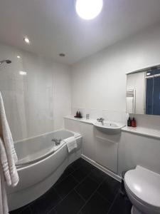 剑桥Westminster College Cottages, Cambridge的带浴缸和水槽的白色浴室