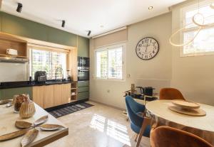 a kitchen with a table and a clock on the wall at L Évasion ZEN Duplex d Exception Entre Plage et Serenite in Mohammedia