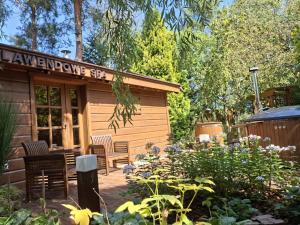 ŻelistrzewoLawendowe Zacisze的一间带椅子和花园的小木屋