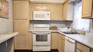 une cuisine avec des appareils électroménagers blancs et des armoires en bois dans l'établissement The Windsor Cottage, à Cape May 19 autres photos