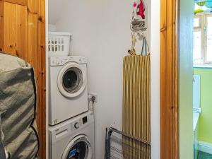 a laundry room with a washer and a washing machine at Erw Goed Old Barn in Arthog