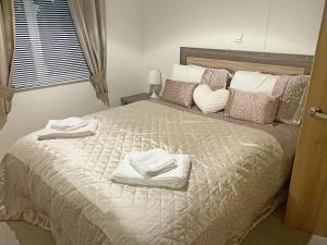 a bedroom with a large bed with towels on it at Sunset Lodge in Lancaster +9 photos