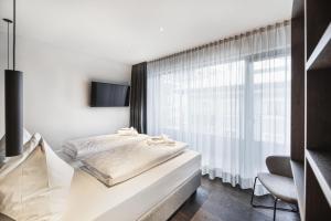 a bedroom with a bed and a window at Aquila Dolomites Residence in Ortisei