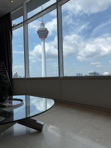 a room with a glass table and a view of a tower at vortex luxury apartment klcc in Kuala Lumpur