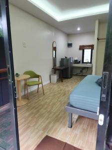 a room with a bed and a table and a desk at Baan Reena Lanta Resort in Ko Klang