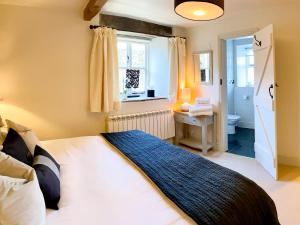 1 dormitorio con 1 cama y baño con ventana en The Owlery At Aysgarth, en Aysgarth